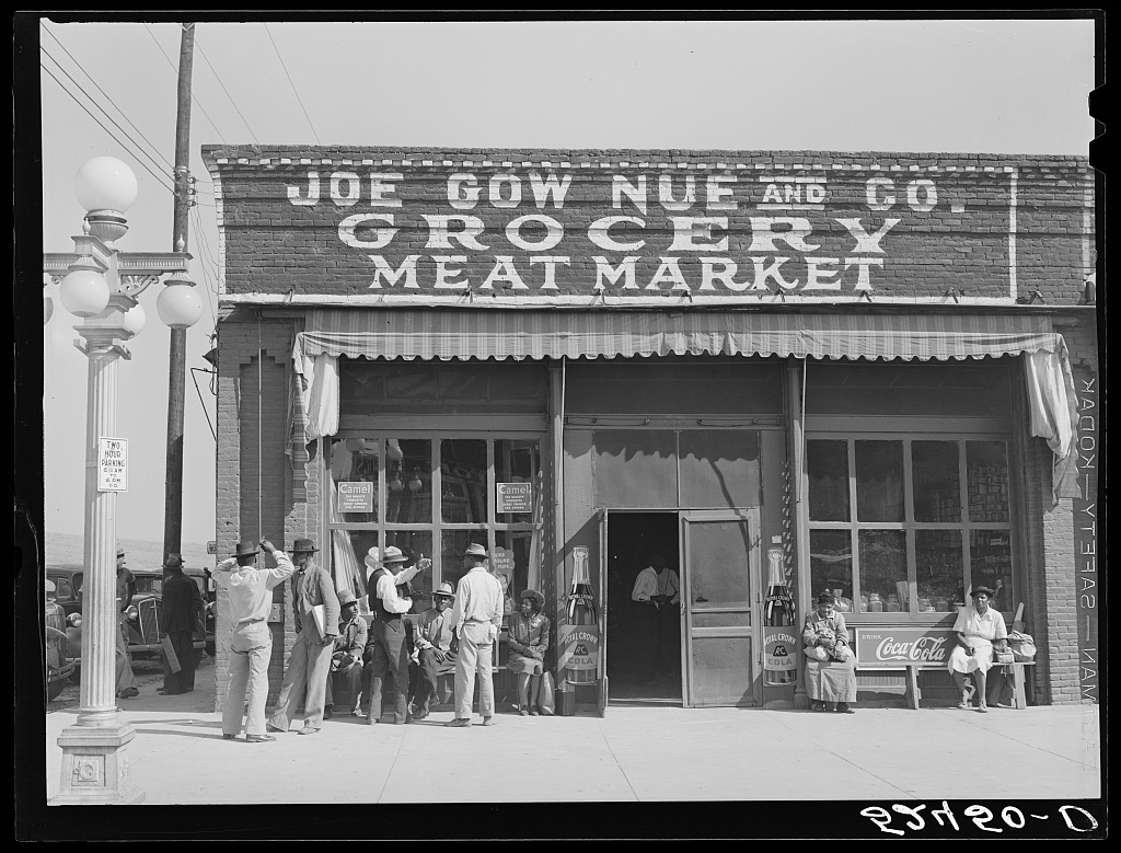 Joe Gow Nue and Co., Grocery and Meat Market: people gather outside the brick storefront in Leland.